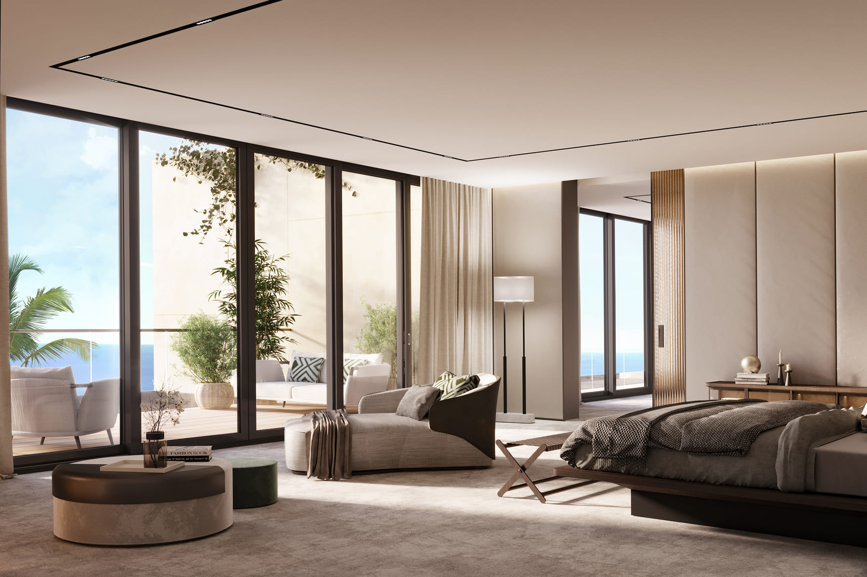 A luxurious bedroom with floor-to-ceiling windows offering a sea view, a large bed, and a sitting area with a round ottoman, in a neutral color scheme.